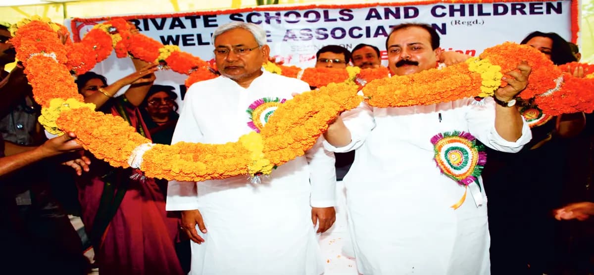 Guests on stage honoured with a marigold garland in front of the association's banner